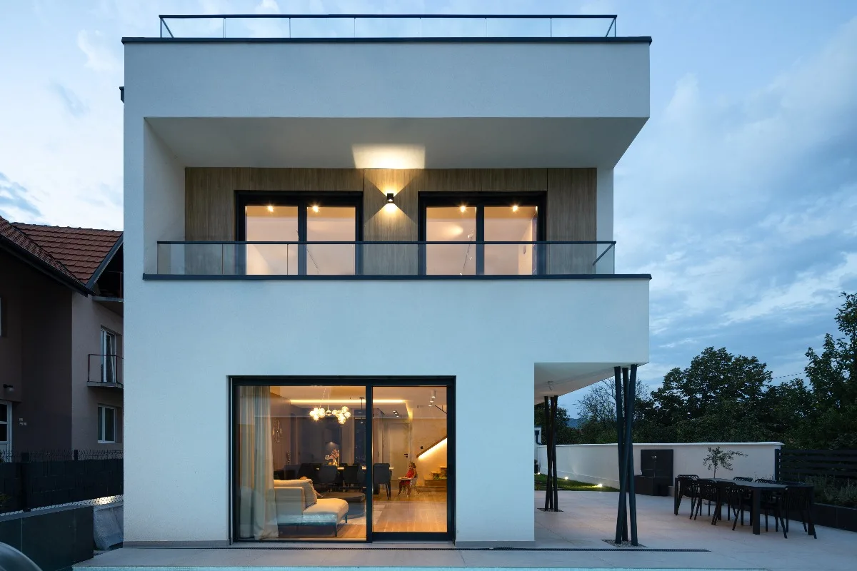 moderna vila bele bojem sa velikim staklenim prozorima i vratima